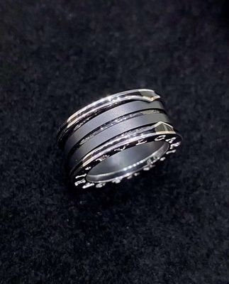 Une bague en or de luxe de 18 carats avec deux boucles en or blanc de 18 carats et une spirale en céramique noire.